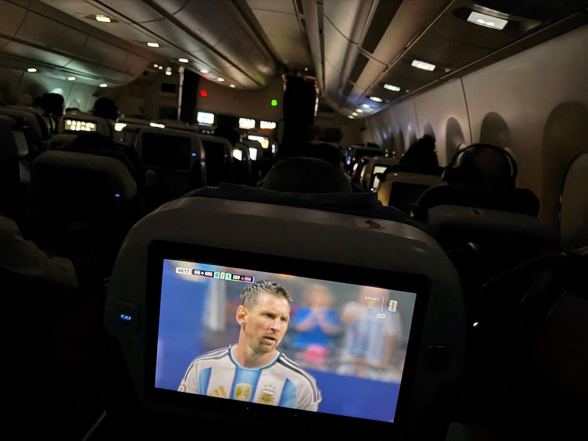 Argentina followed everywhere: Messi on the seat-back screen as comeback day became a travelling ritual.