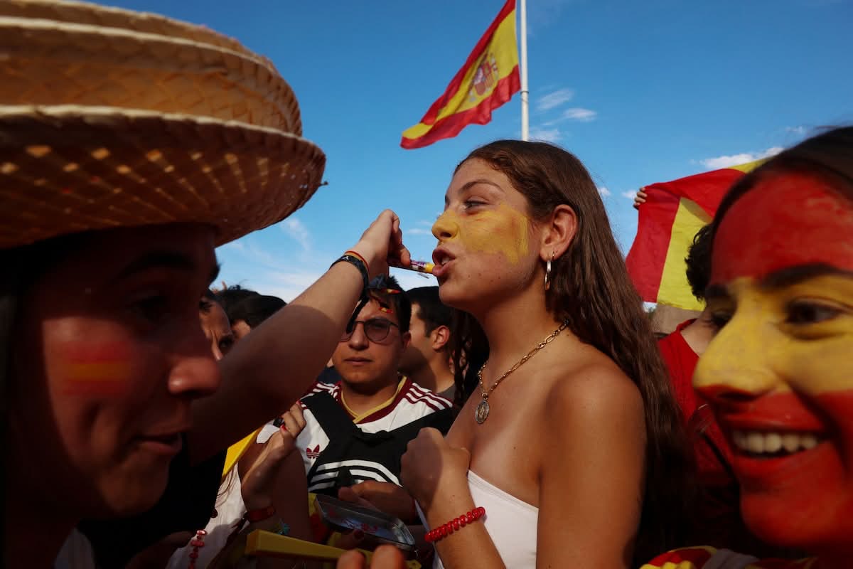 Hinchas de España con la cara pintada y la bandera