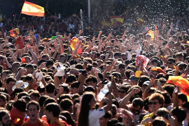 Multitud de aficionados de España celebra con banderas en una fan zone