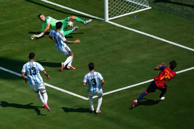 Un jugador de España remata al arco defendido por Emiliano Martínez