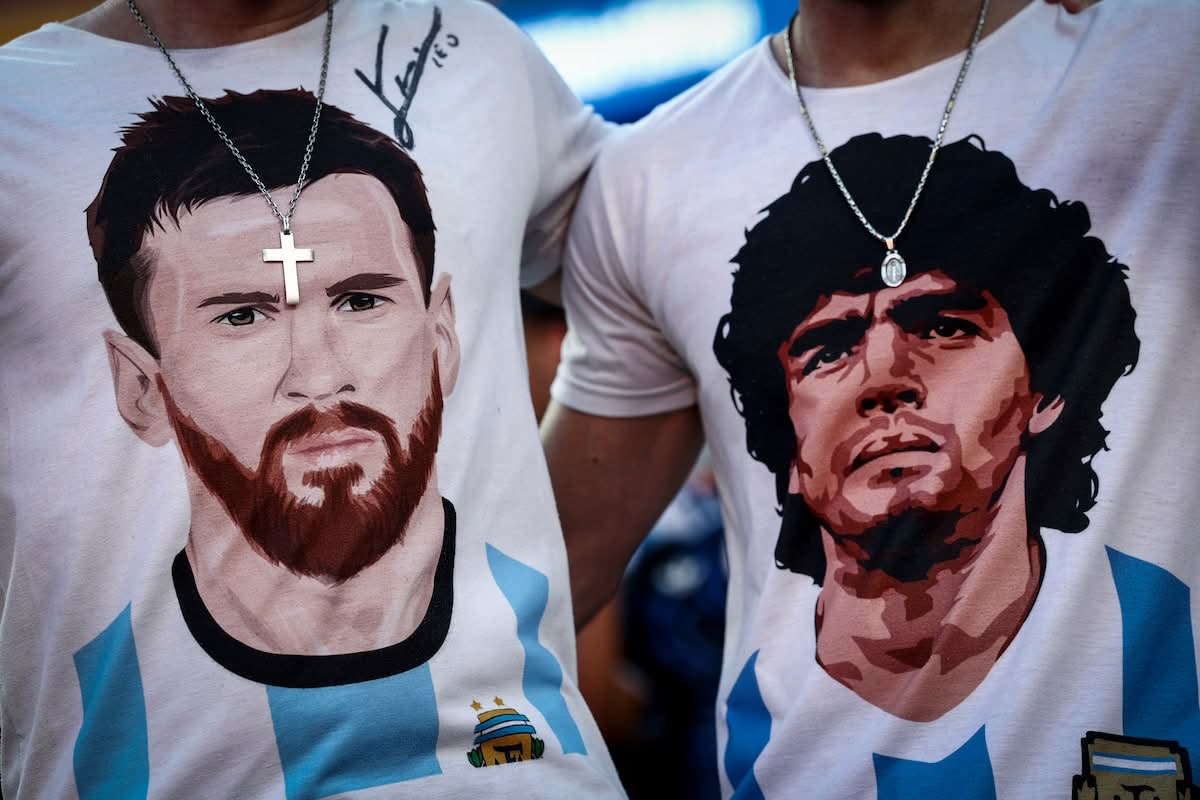 Two Argentina fans wear t-shirts with Messi and Maradona portraits