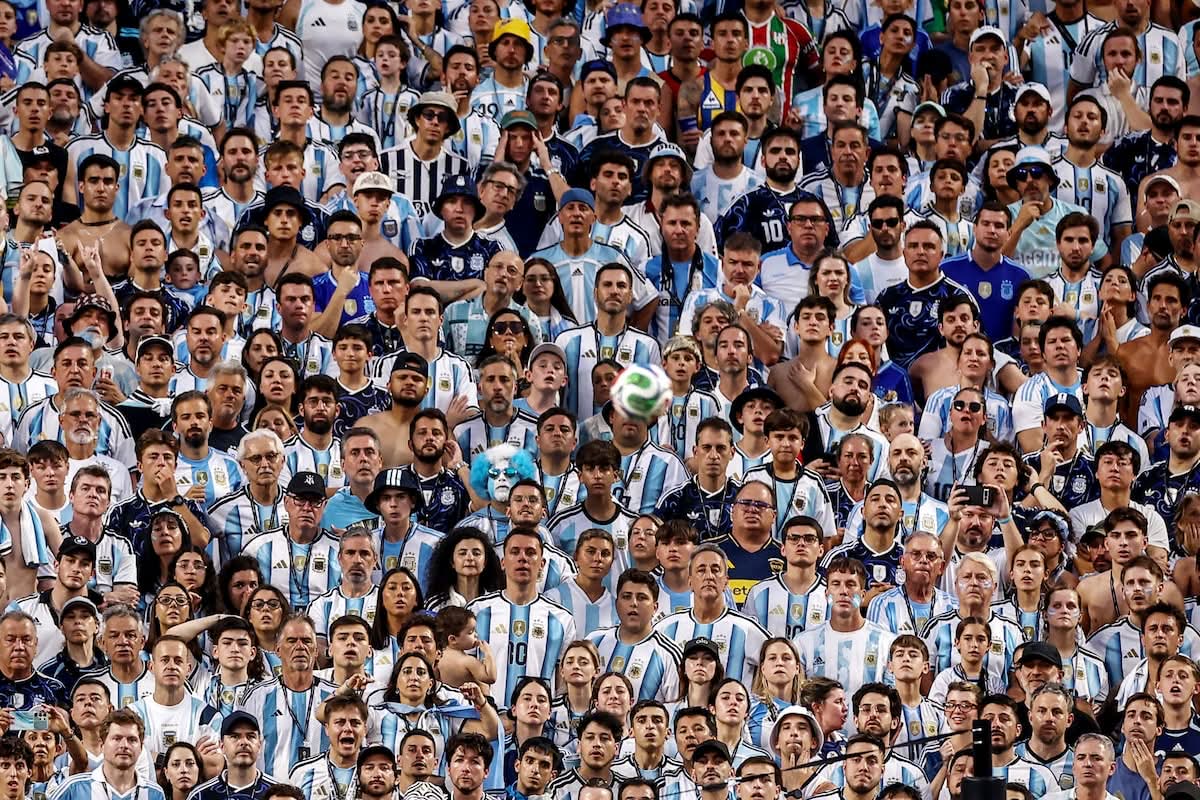 A packed stand of Argentina fans in sky-blue and white watches the quarter-final