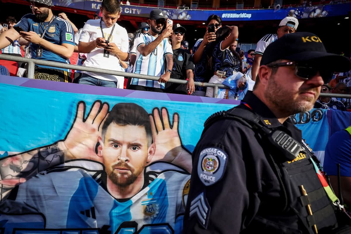 A Messi banner hangs as a Kansas City police officer stands guard by Argentina fans