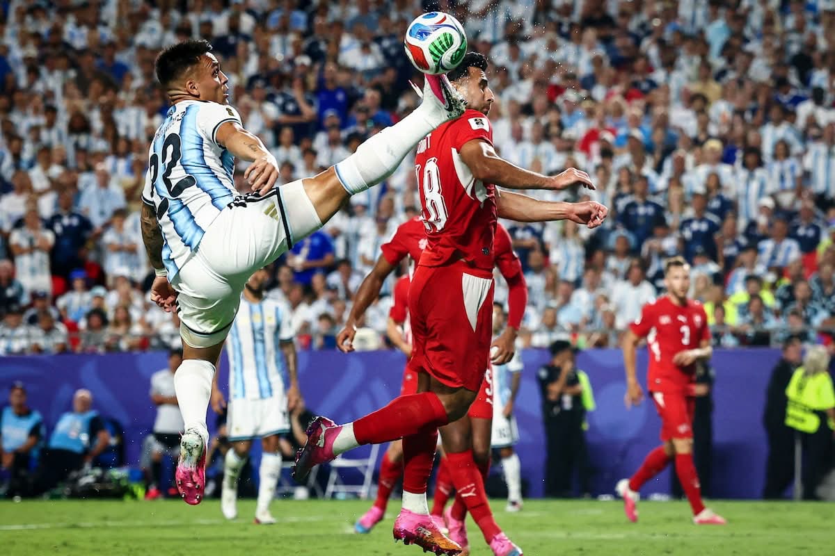Lautaro Martinez stretches for a high ball in an aerial duel with Switzerland