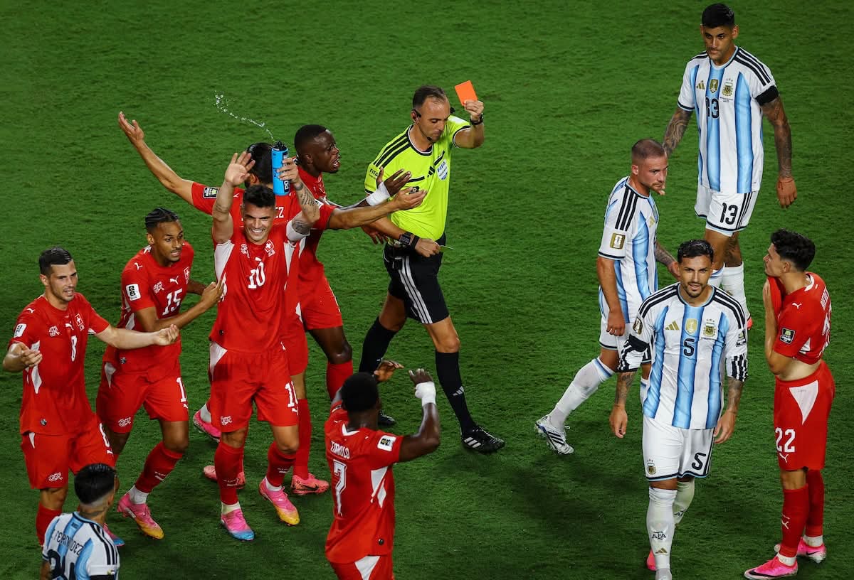 Referee shows a red card as Switzerland players protest during the quarter-final